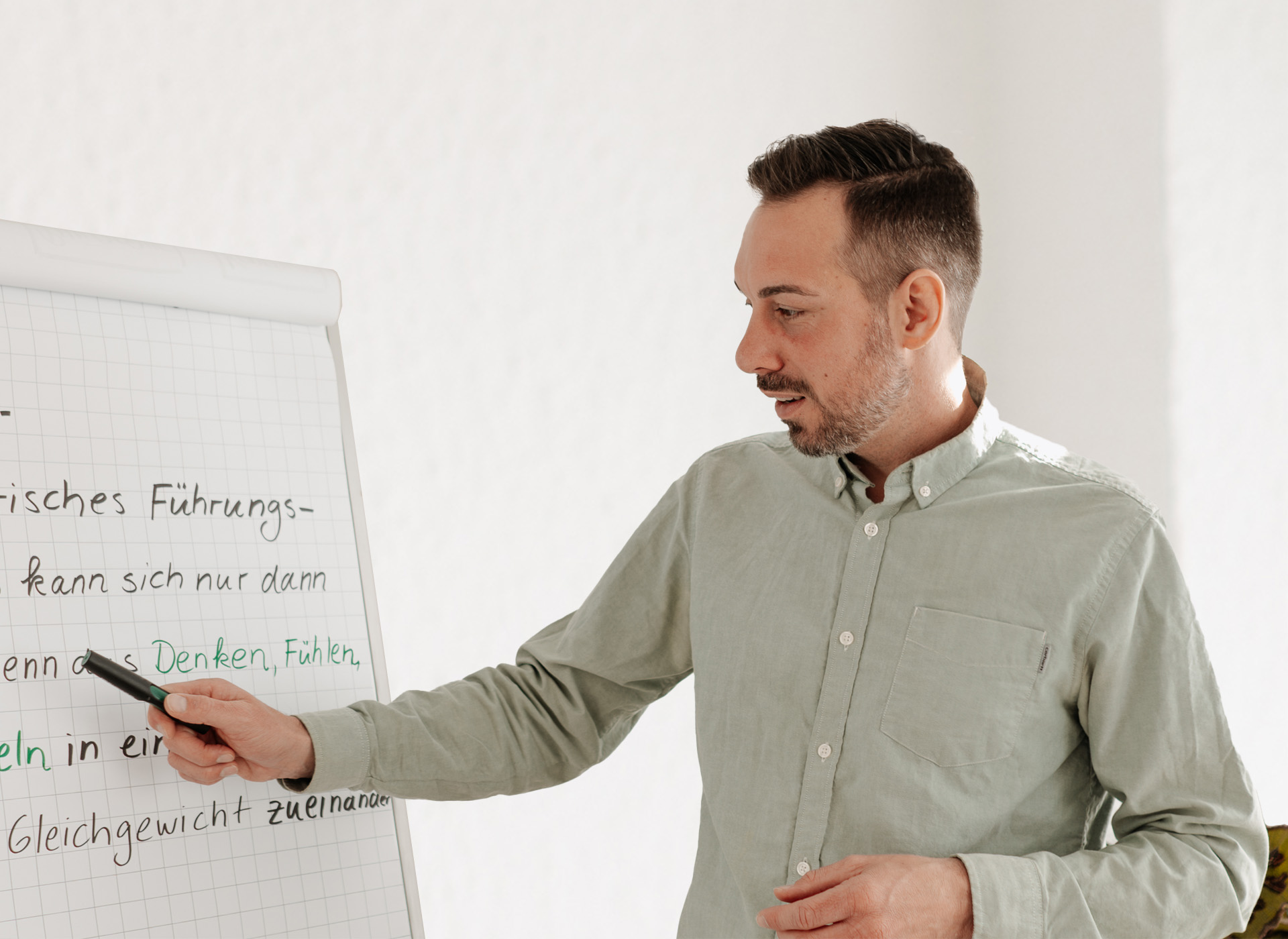 Seminare für Stressbewältigung & Konfliktlösung Coach Ben präsentiert Inhalte am Flipchart – Workshop oder Seminarvermittlung
