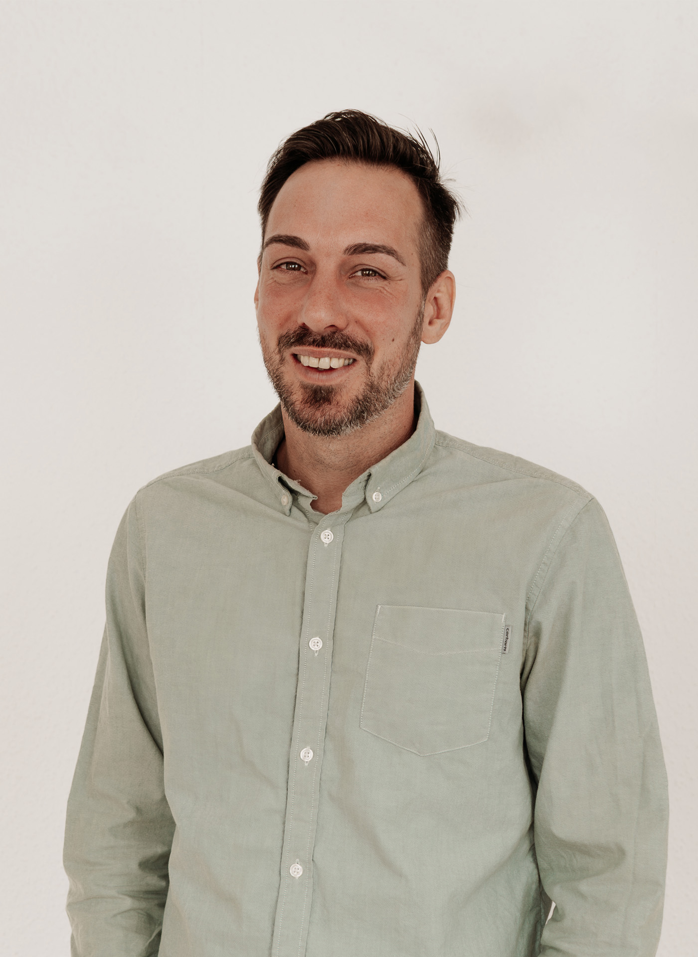 Impulsgebende Seminare und Coaching Portrait von Ben Sembritzki, Coach und Gründer von SEIN & SELBST – freundlich und offen im Hemd vor hellem Hintergrund